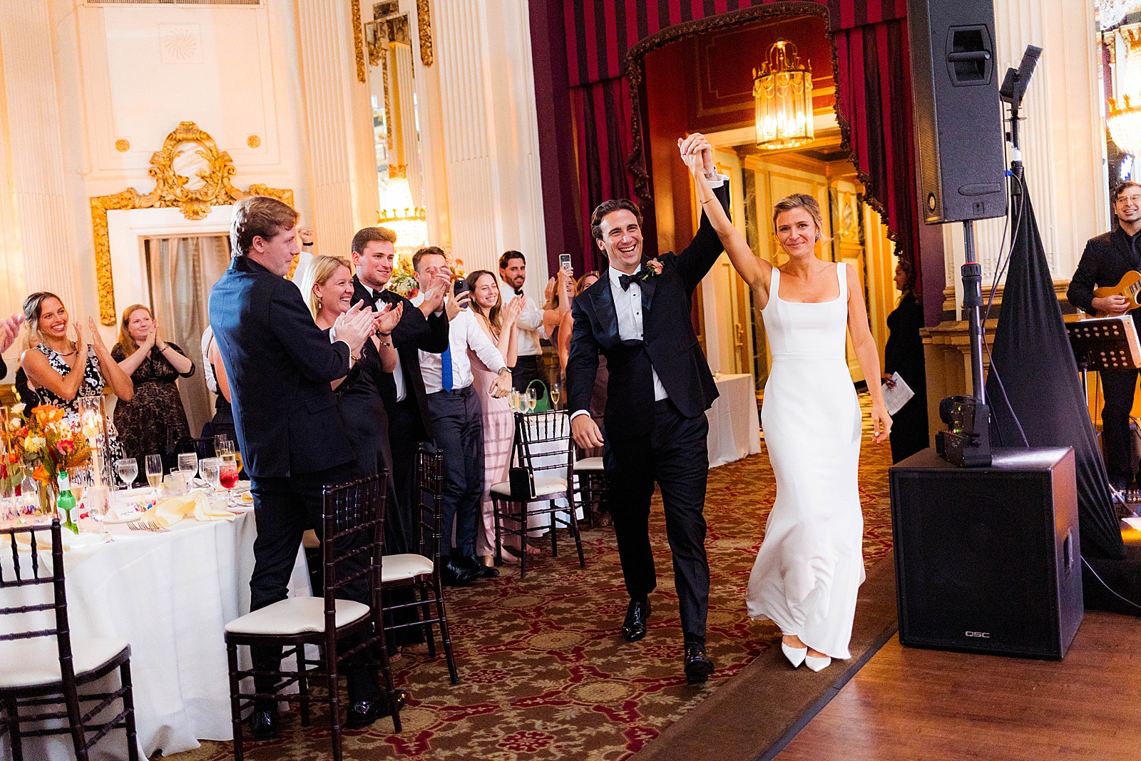 Bride and groom enter reception to crowd clapping