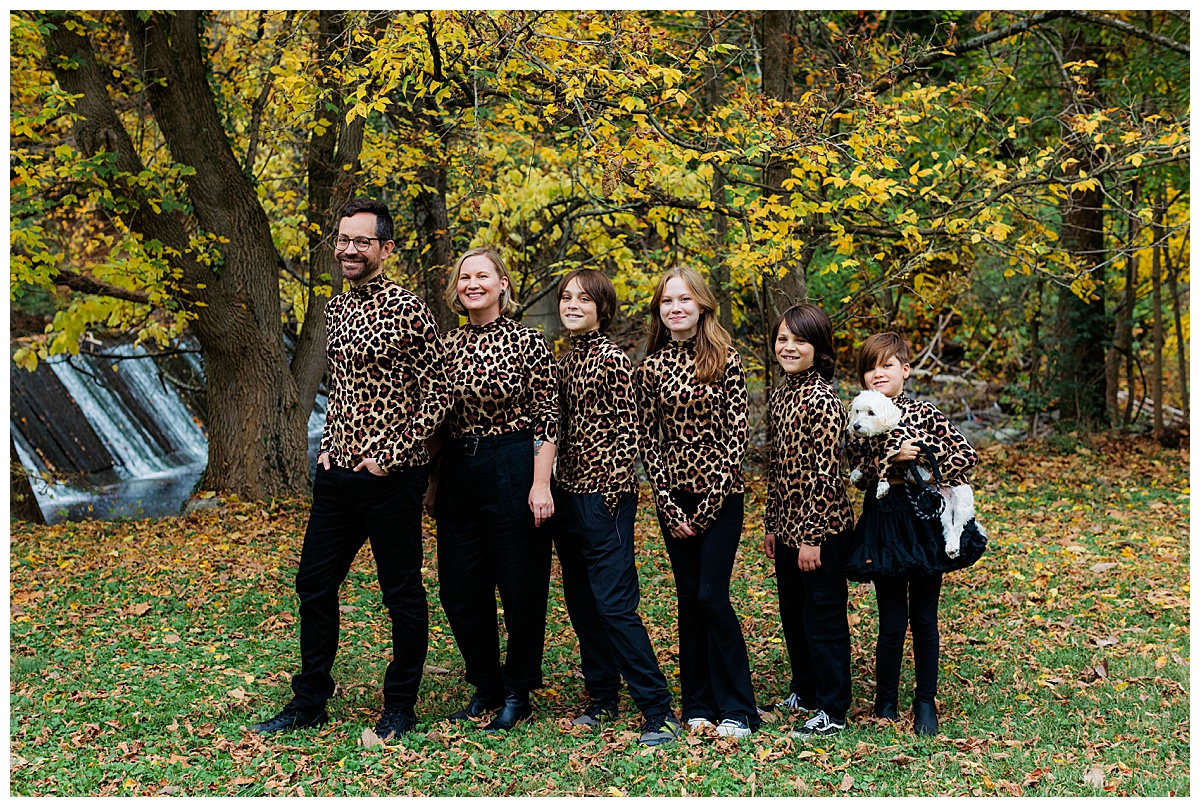 Family recreates an awkward family photo with everyone standing in a line and wearing matching leopard turtlenecks. 