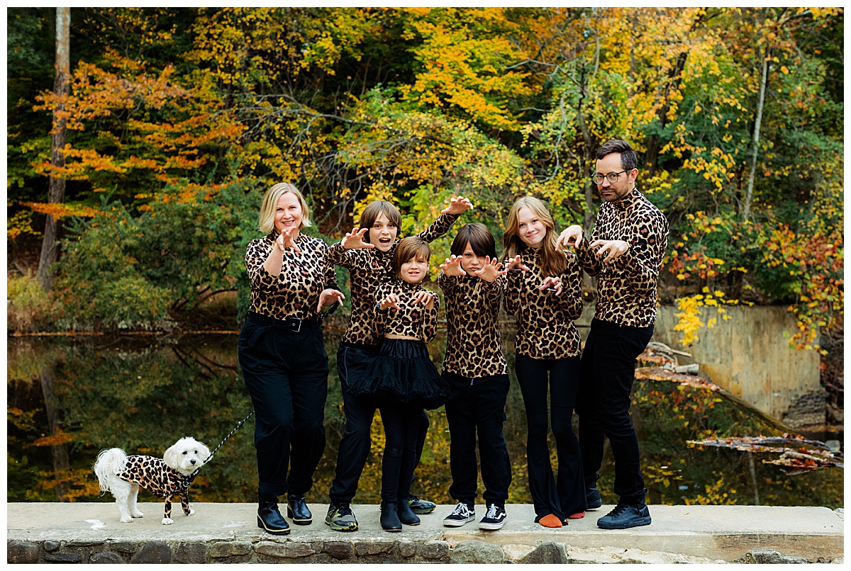 Family wearing matching outfits makes leopard rawr hand gestures at camera for their awkward family photos in Baltimore.