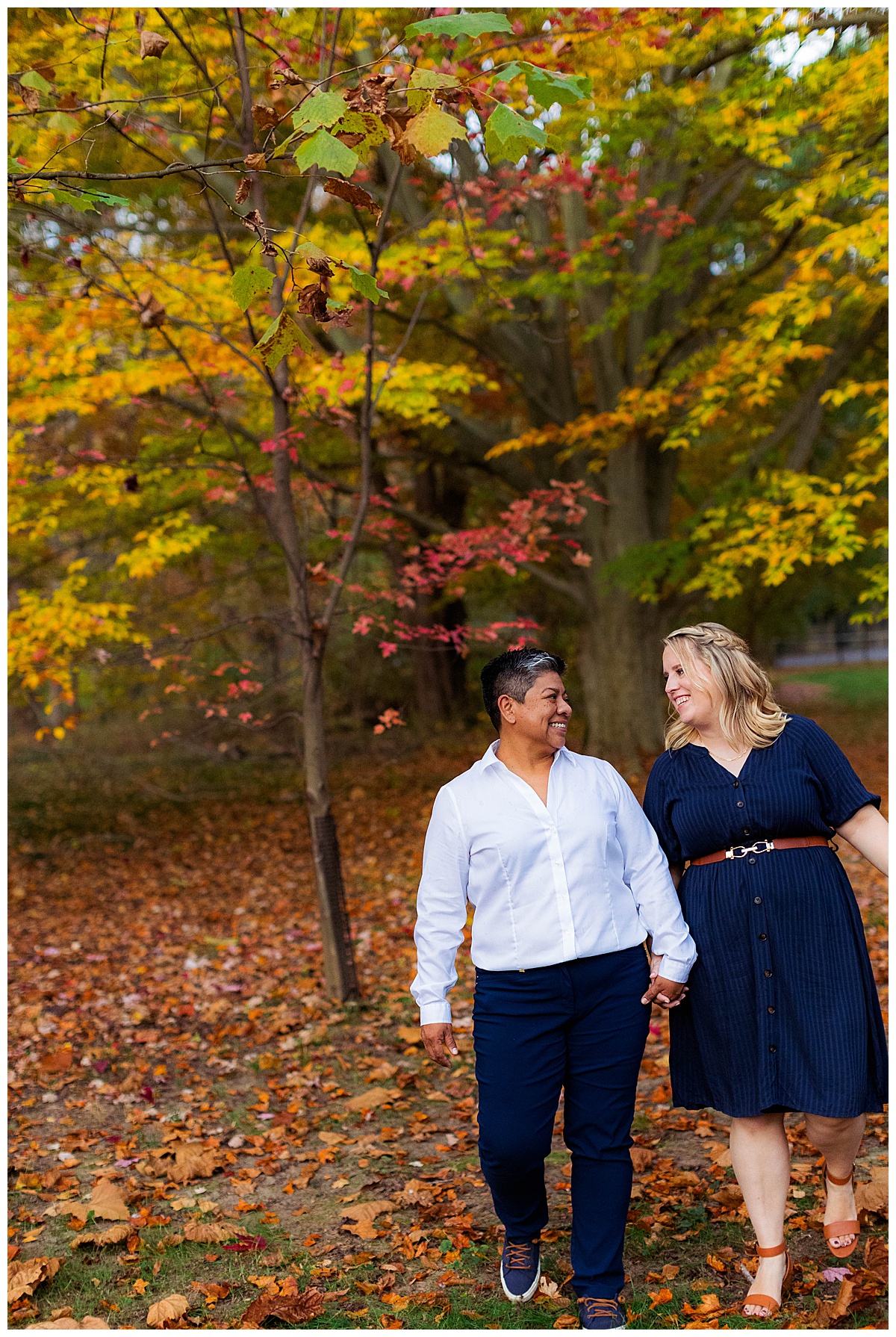 LGBTQ couple walks through fall leaves in sligo creek park