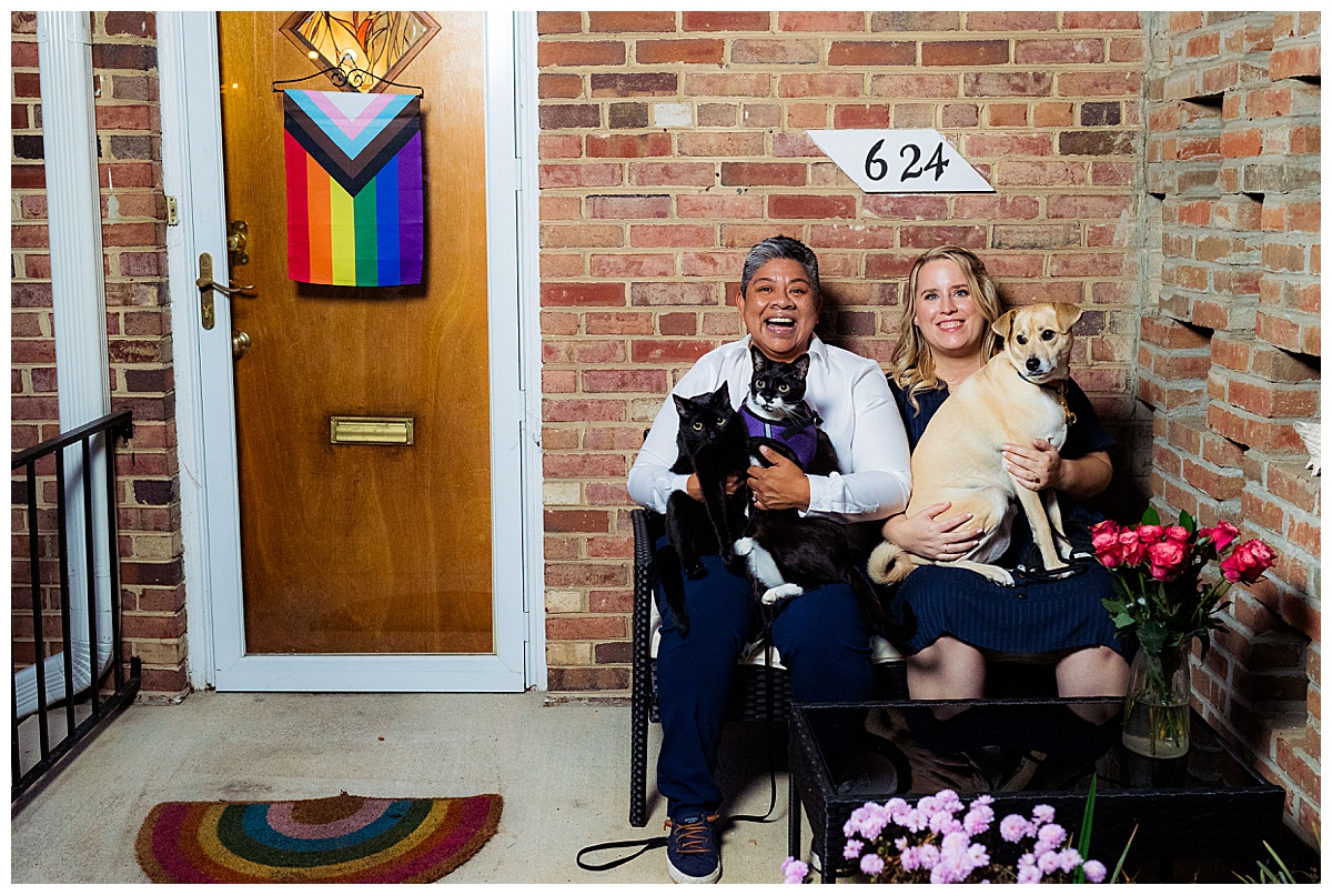 LGBTQ couple pose outside their house in Takoma Park for engagement photos with their two cats and a dog