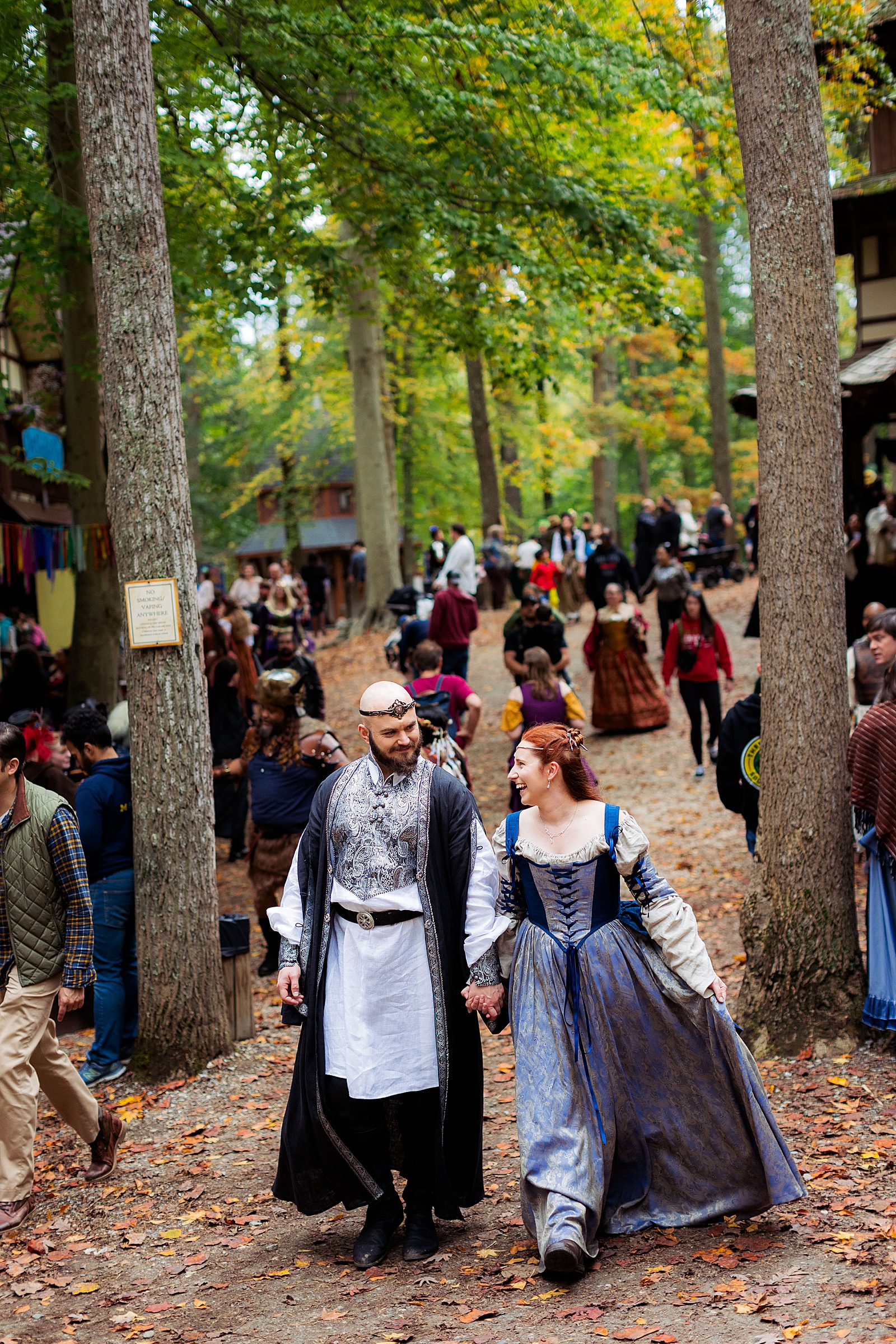 Bride and groom walk through Revel Grove after their wedding at the MD Renn Fest. 
