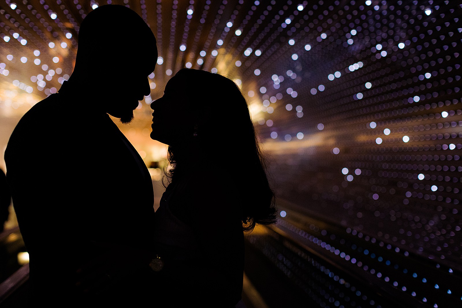 A couple is silhouetted by the lights of the Multiverse light installation at the National Gallery of Art in DC. 