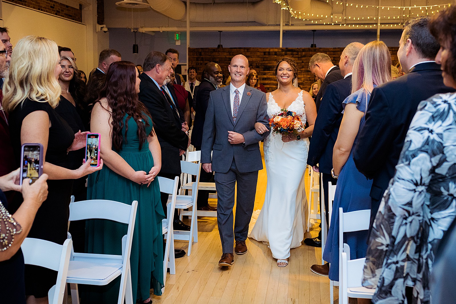 Bride and her father walk down the aisle inside the AVAM in Baltimore. 