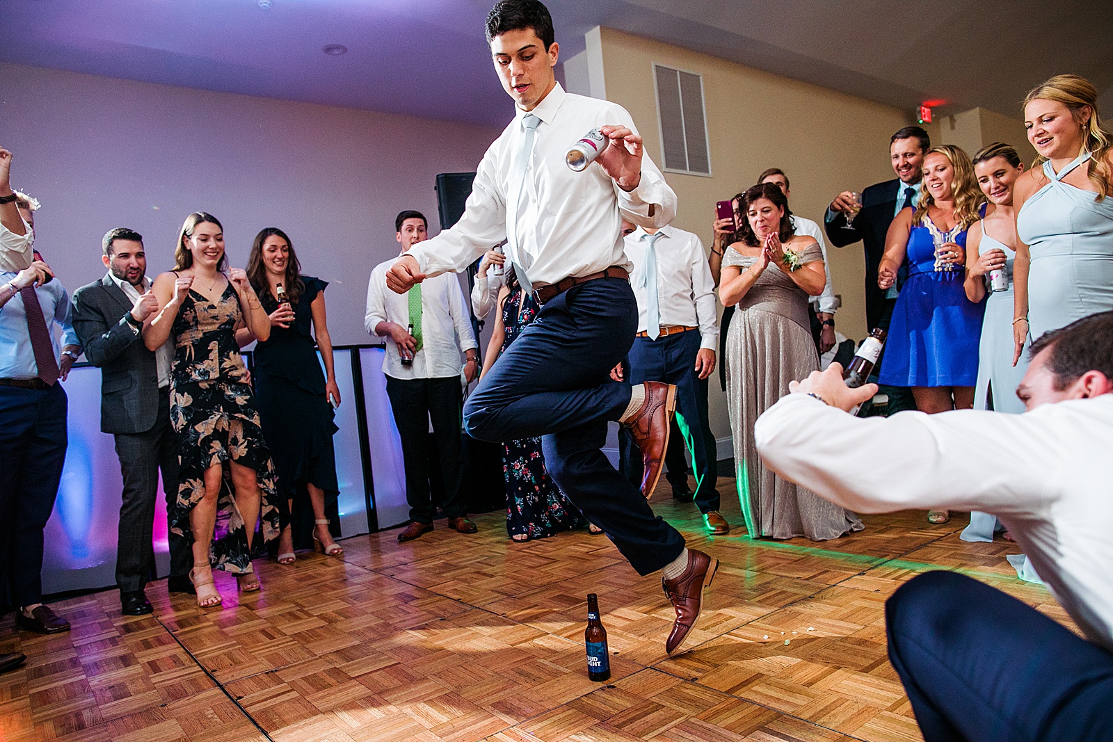 Wedding guest dances around a bottle at an indoor wedding reception at Springfield Manor. 