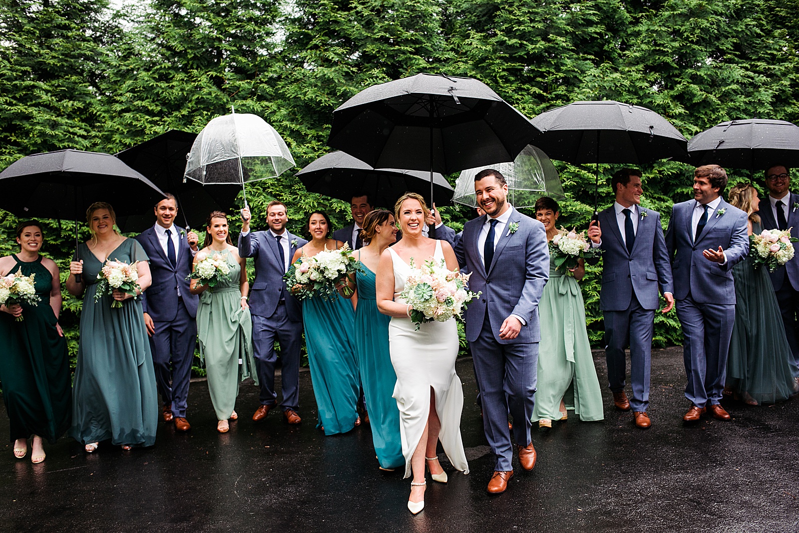 Wedding party has fun with umbrellas during rainy wedding portraits to illustrate the importance of having a back up plan. "Does your photographer have a backup plan?" is one of my top questions to ask your wedding photographer before booking. 