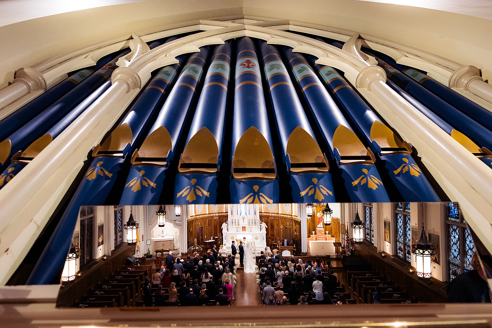 View of the wedding ceremony at Immaculate Conception church in DC reflected in the mirror of the organ.