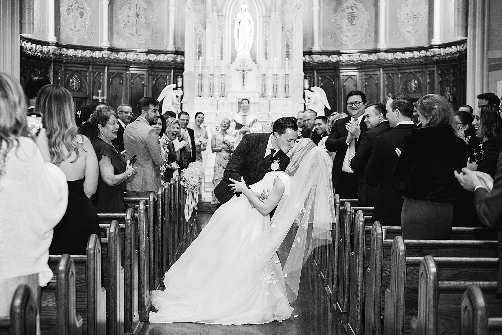 Bride and groom kiss with a dip in the aisle during their recessional before heading to the rest of their rainy Mount Vernon Inn Restaurant wedding.