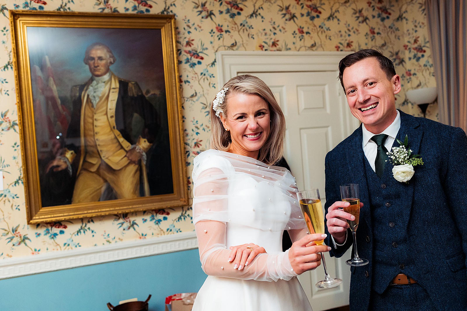 Bride and groom cheers with a portrait of George Washington behind them at their rainy Mount Vernon Inn Restaurant wedding.